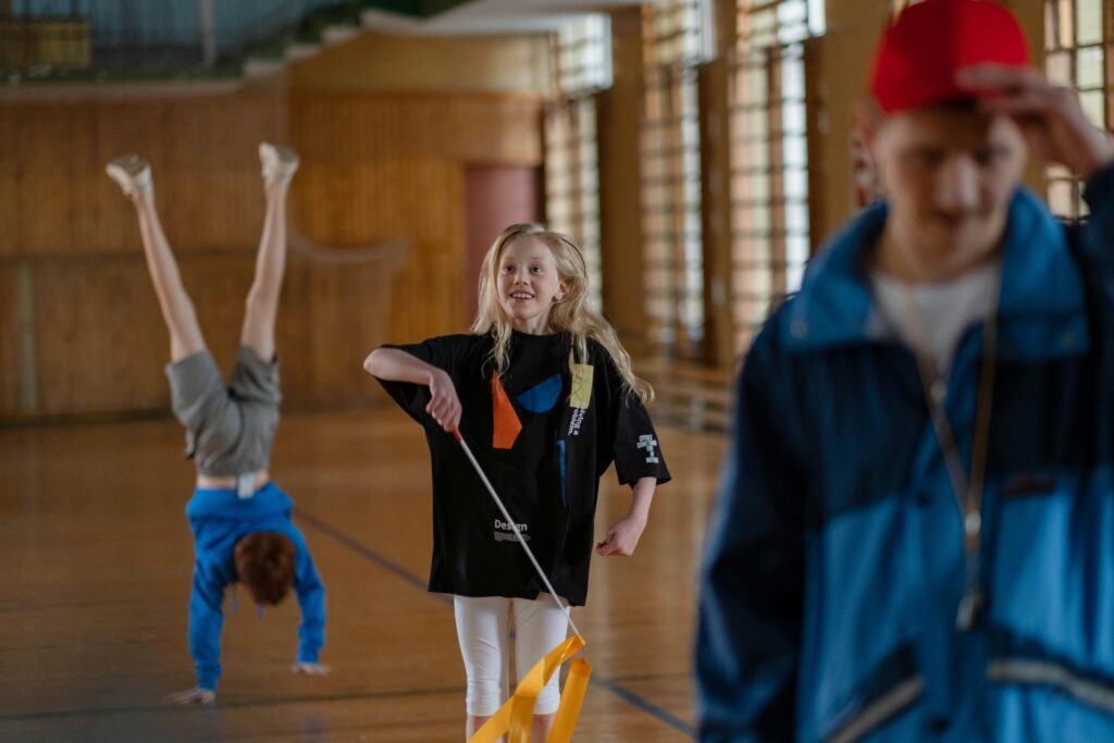 Children having fun in a school gym, with gymnastics and playful activities.