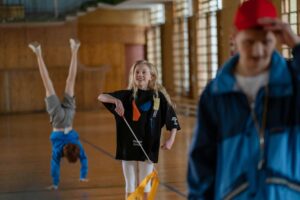 Children having fun in a school gym, with gymnastics and playful activities.